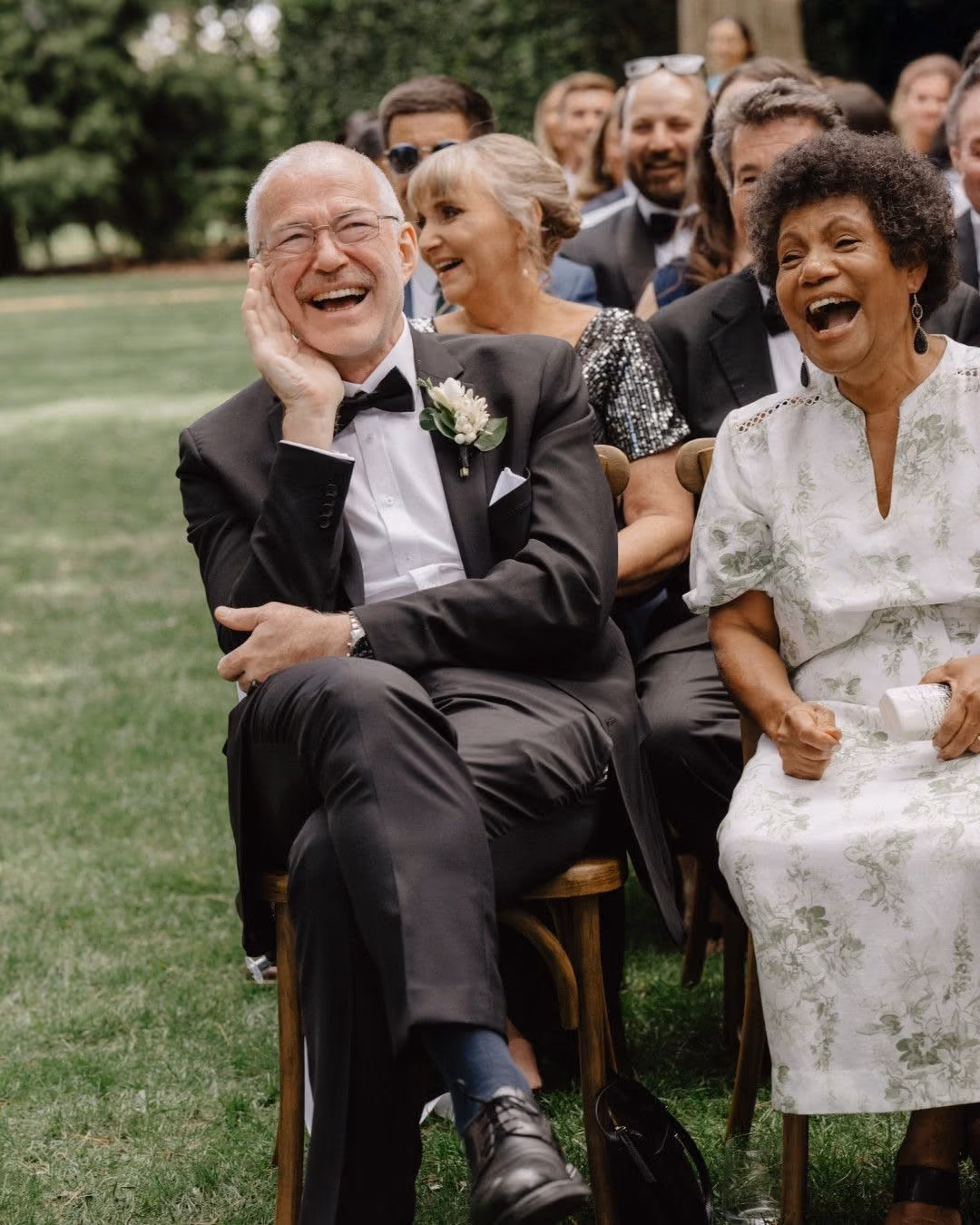Wedding guests laughing at an outdoor ceremony