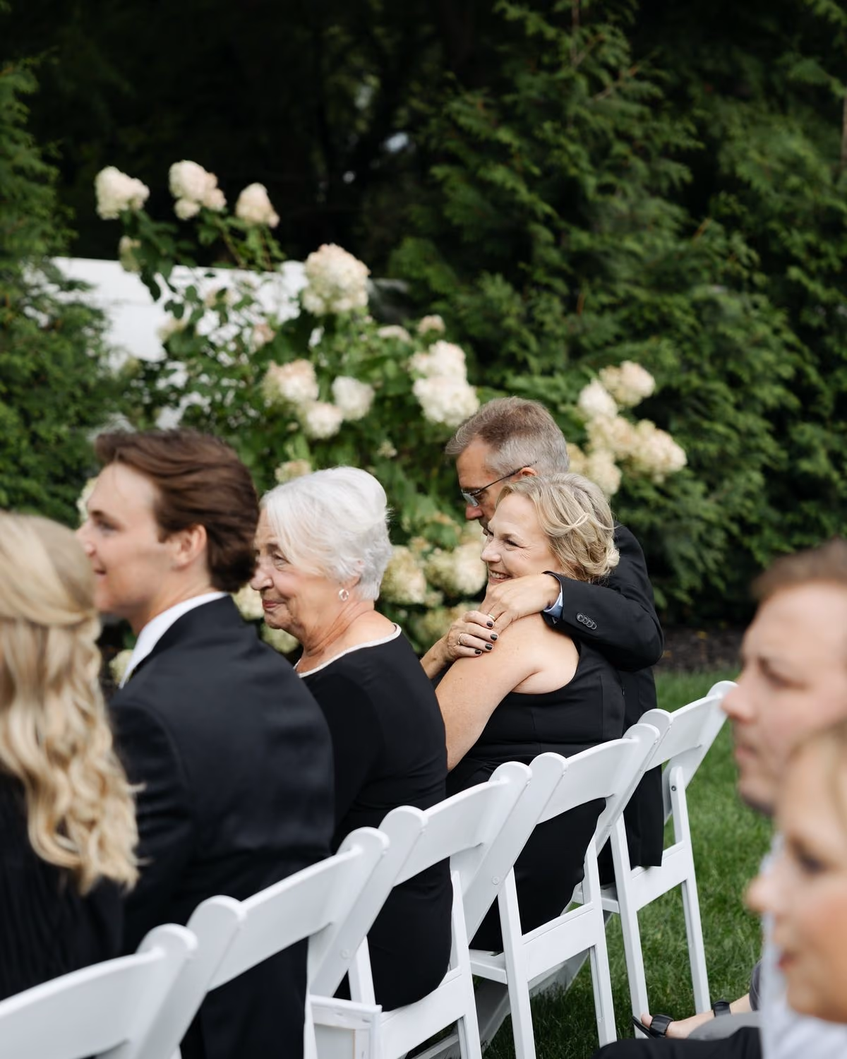 Guests smiling during an outdoor wedding ceremony